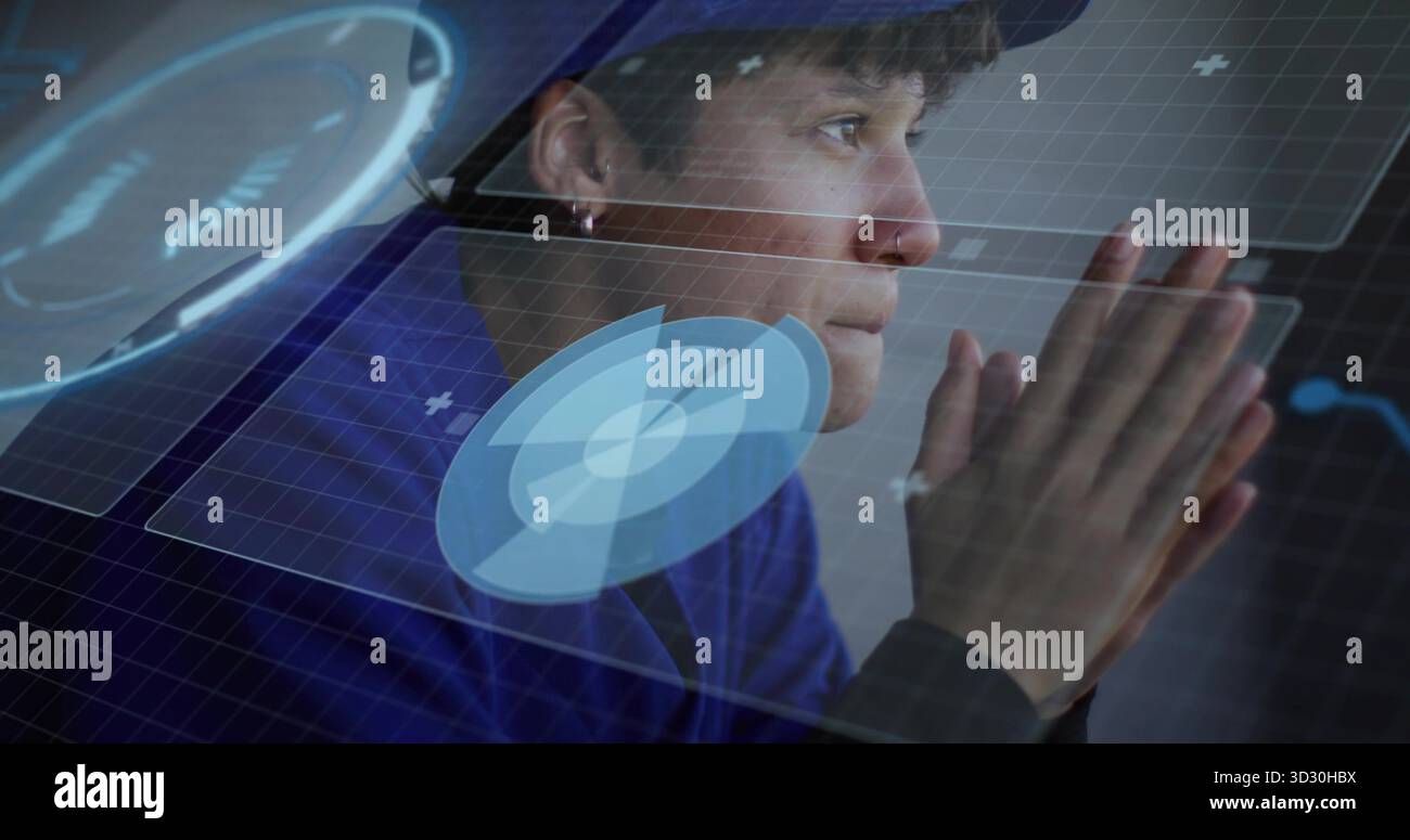 Donna seduta che interagisce con pannelli olografici sulla postazione di lavoro, con grafici circolari Foto Stock