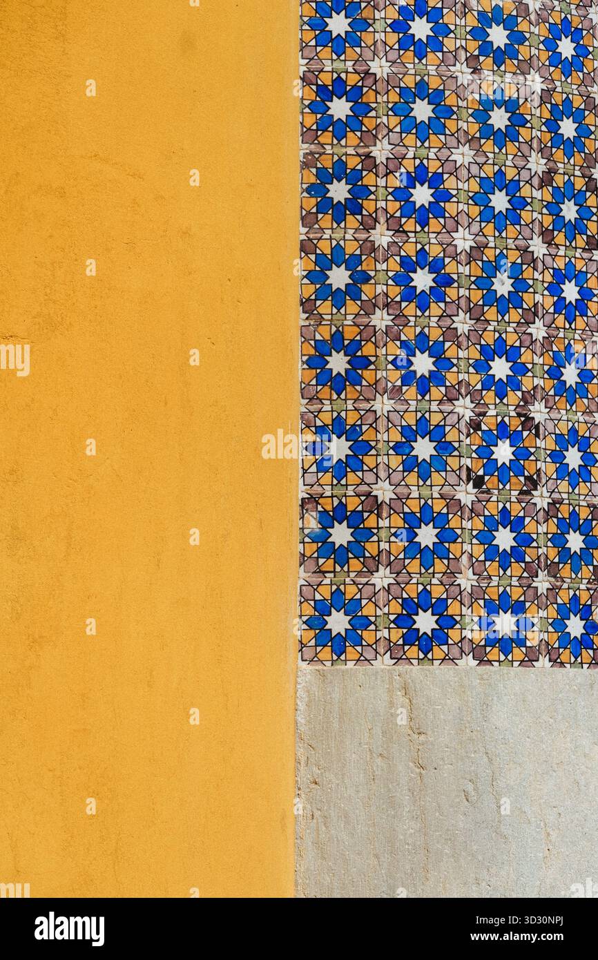 Piastrelle geometriche a forma di stella Azulejo e muratura in stucco giallo testurizzato a Lisbona, Portogallo Foto Stock