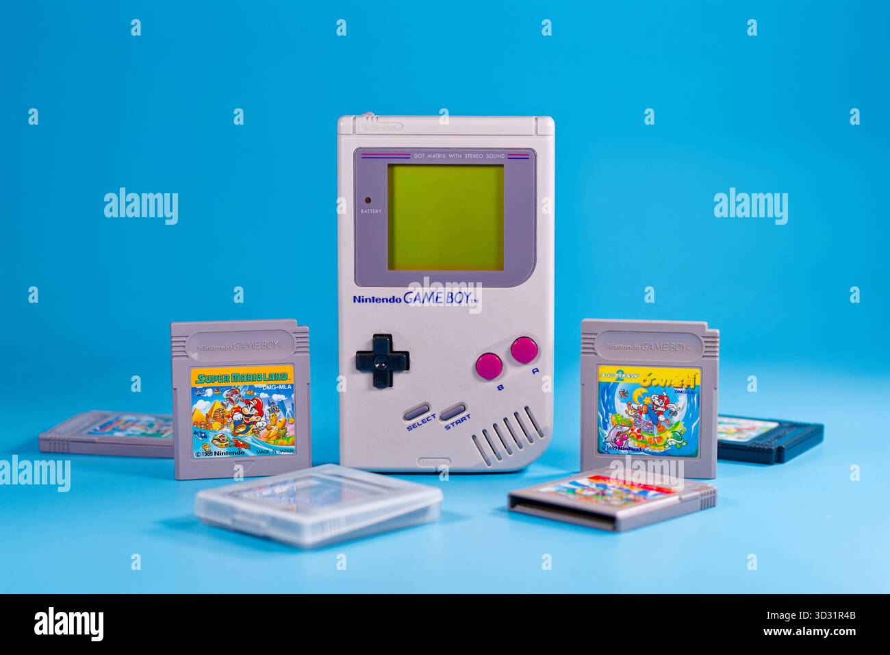 Fukuoka, Giappone - 4 novembre 2025: nintendo game boy con varie cartucce di gioco isolate su sfondo blu Foto Stock