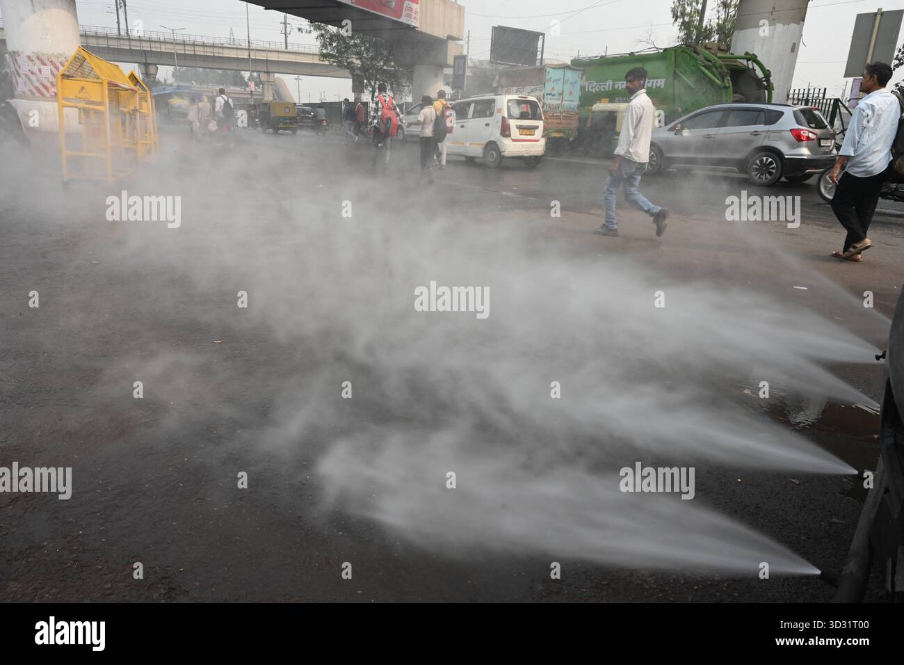 NUOVA DELHI, INDIA - 1 NOVEMBRE: Una pistola antismog ha visto spruzzare acqua per depositare le particelle di polvere come uno spesso strato di smog inghiottito nelle prime ore del mattino al terminal degli autobus di Anand Vihar, il 1° novembre 2025 a nuova Delhi, India. Secondo il CPCB (Central Pollution Control Board), il capitale nazionale ha registrato un AQI dell’indice di qualità dell’aria pari a 357, rispetto ai 279 del giorno prima. Il calo della qualità dell'aria è stato accompagnato da una ridotta visibilità in diverse parti della città, in quanto la nebbia e i venti calmi hanno intrappolato gli inquinanti vicini al terreno. Foto di Sonu Mehta/Hindustan Times Dense Smog Engul Foto Stock