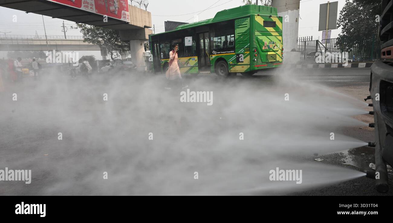 NUOVA DELHI, INDIA - 1 NOVEMBRE: Una pistola antismog ha visto spruzzare acqua per depositare le particelle di polvere come uno spesso strato di smog inghiottito nelle prime ore del mattino al terminal degli autobus di Anand Vihar, il 1° novembre 2025 a nuova Delhi, India. Secondo il CPCB (Central Pollution Control Board), il capitale nazionale ha registrato un AQI dell’indice di qualità dell’aria pari a 357, rispetto ai 279 del giorno prima. Il calo della qualità dell'aria è stato accompagnato da una ridotta visibilità in diverse parti della città, in quanto la nebbia e i venti calmi hanno intrappolato gli inquinanti vicini al terreno. Foto di Sonu Mehta/Hindustan Times Dense Smog Engul Foto Stock