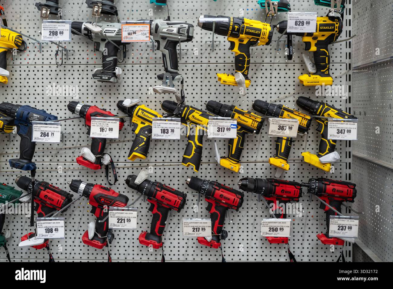 Gamma di trapani elettrici e cacciaviti cordless esposti nel negozio di utensili. Minsk, Bielorussia - 26 giugno 2022 Foto Stock