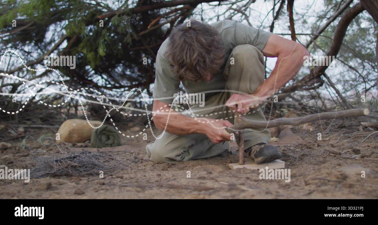 Uomo inginocchiato in camicia verde, pantaloni cachi che premono il mandrino nel tabellone dei pompieri nella macchia, con tinder Foto Stock