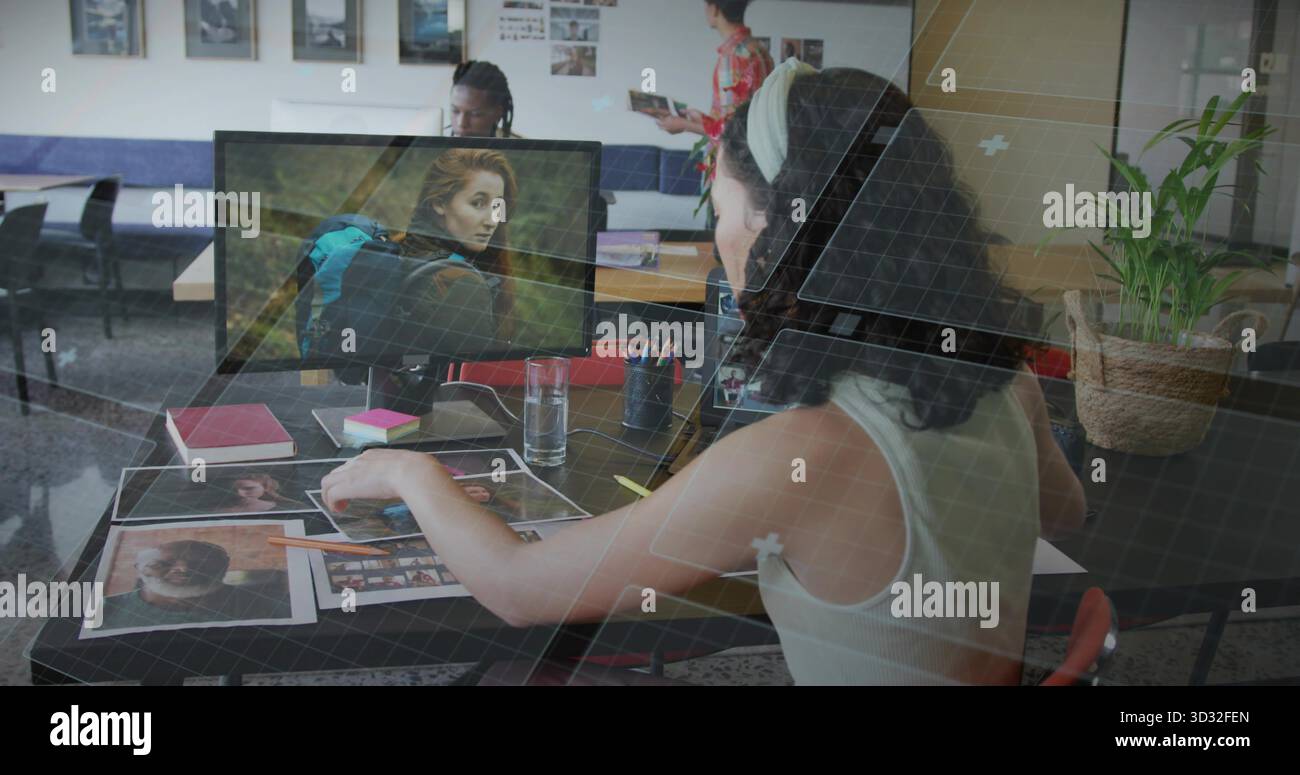 Sistemazione professionale con canotta per l'ordinamento delle fotografie alla scrivania dello studio, con monitor per computer Foto Stock