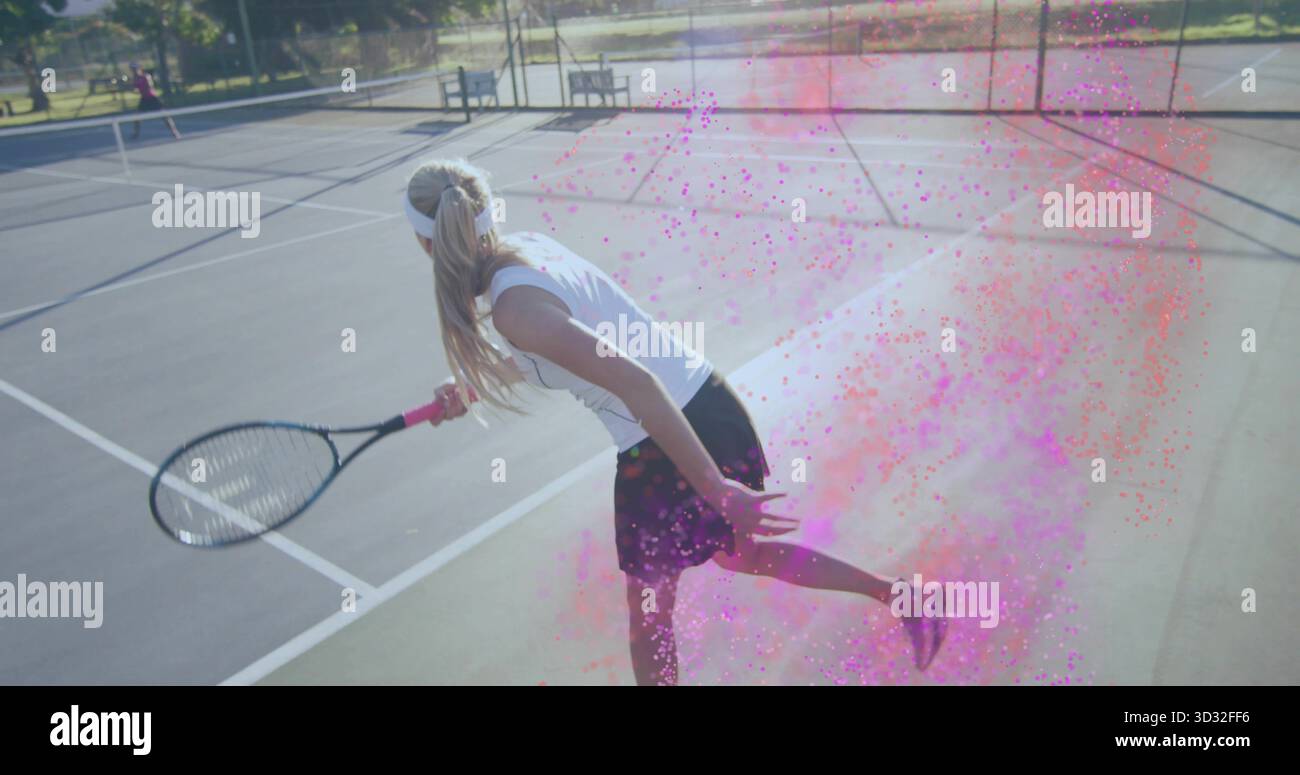 Tennista in affondo che indossa abbigliamento sportivo, tiene la racchetta sul campo all'aperto, con polvere rosa Foto Stock