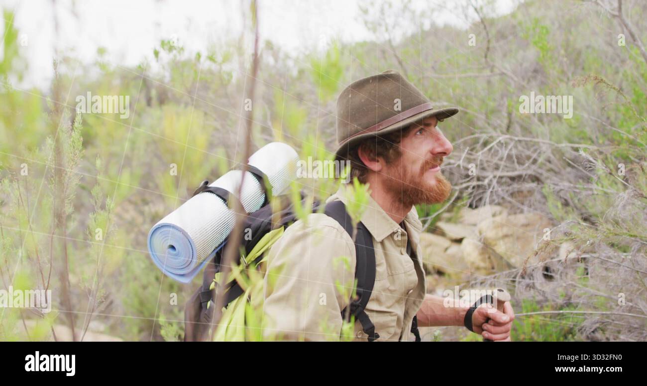 Arrampicata con cappello in feltro utilizzando l'asta da trekking sul sentiero in collina, con zaino che porta il cuscino per dormire Foto Stock