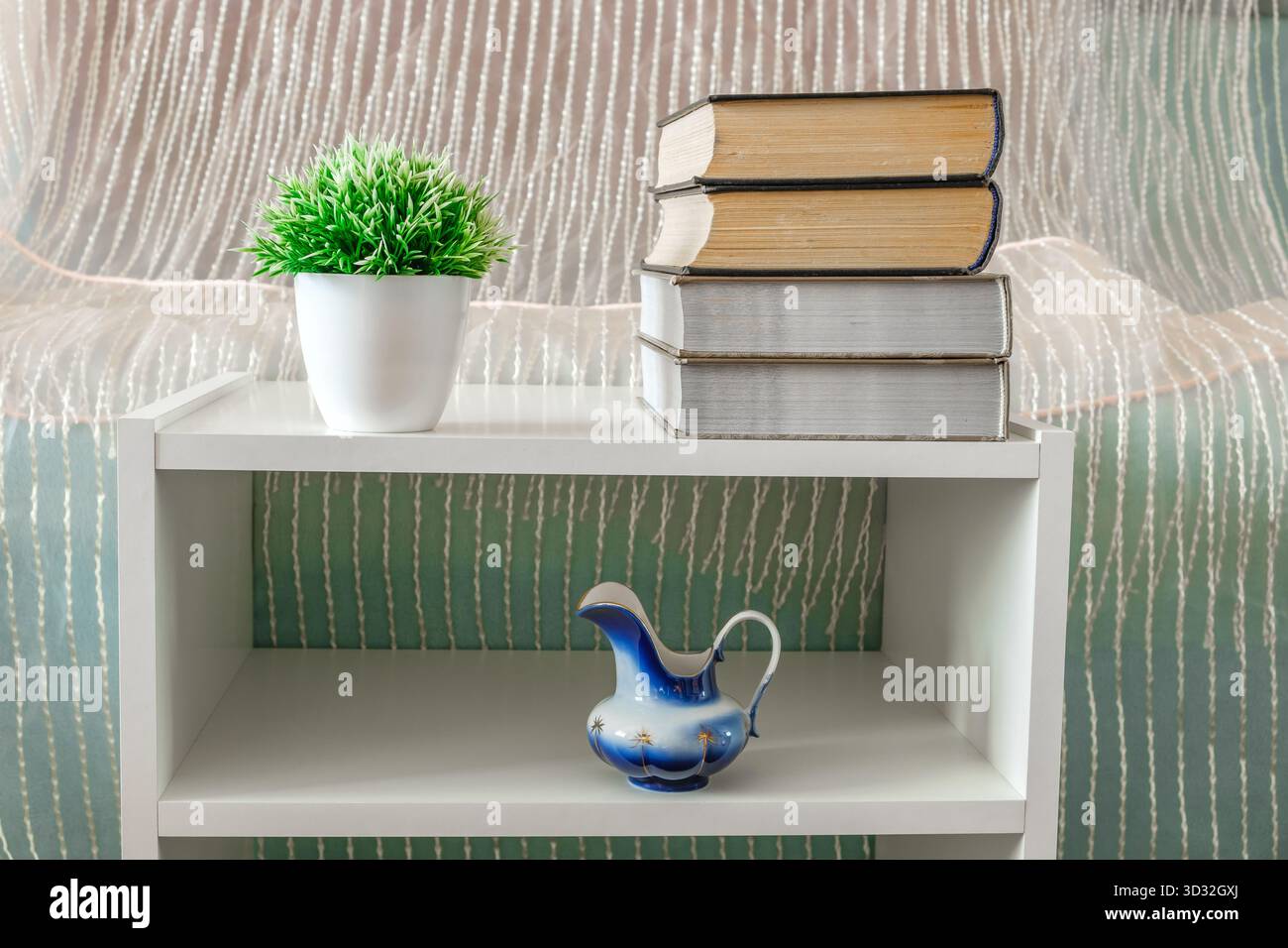 libri, fiori, vaso su libreria bianca Foto Stock