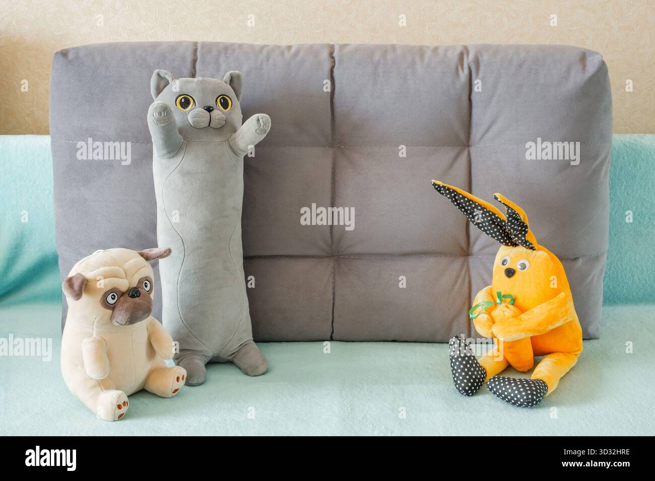 morbidi peluche, cane da gatto e coniglio sul divano Foto Stock