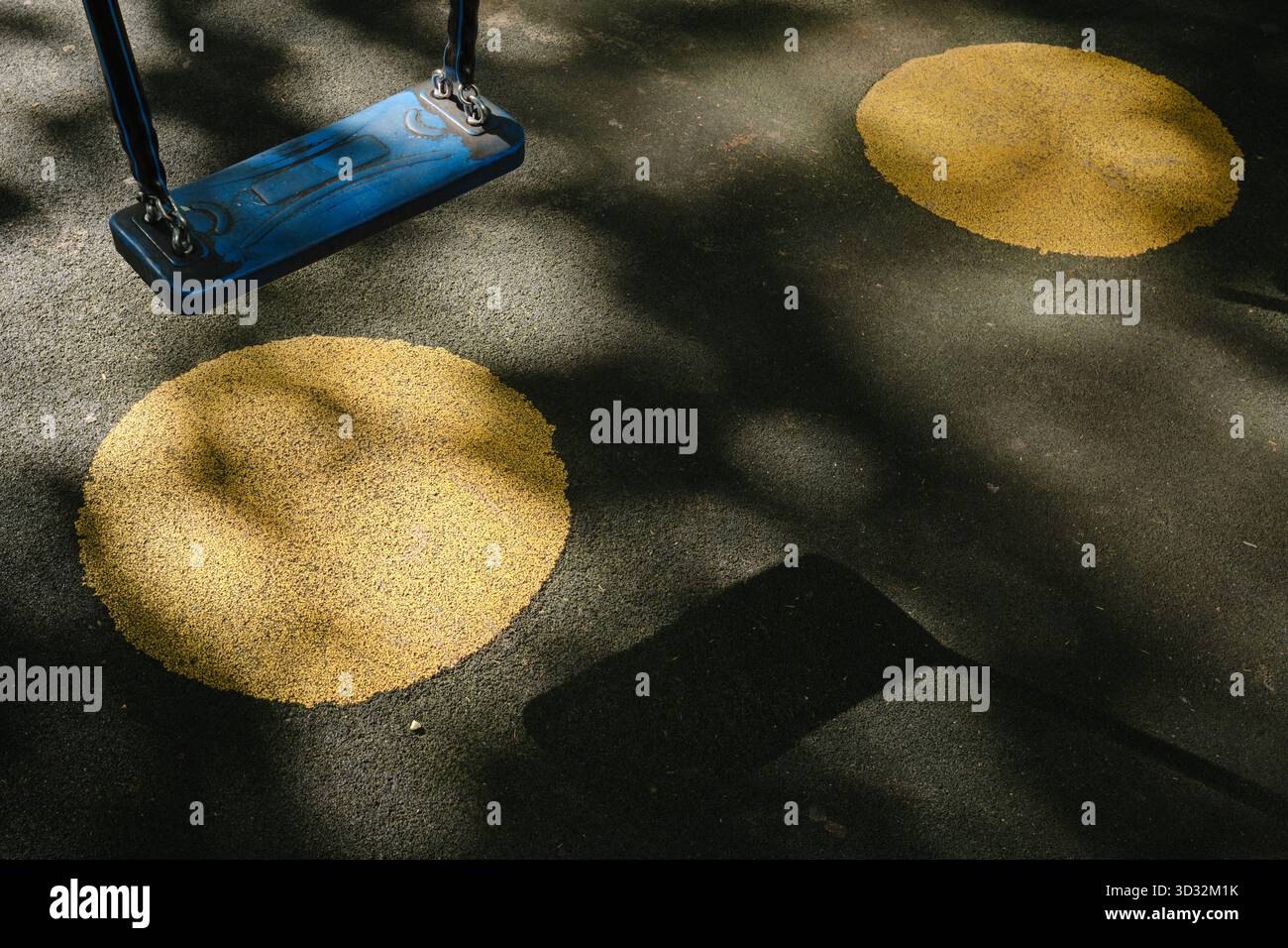 Altalena blu, la sua ombra e 2 cerchi gialli sotto di essa Foto Stock