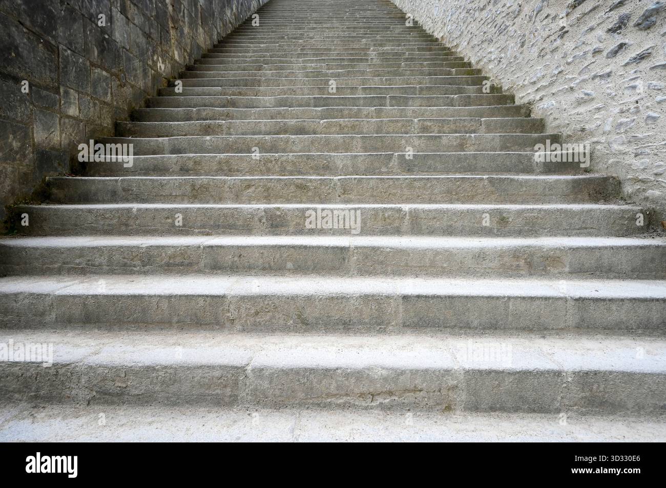 Prospettiva della scalinata in cemento con pareti in pietra come sfondo, per idee concettuali Foto Stock