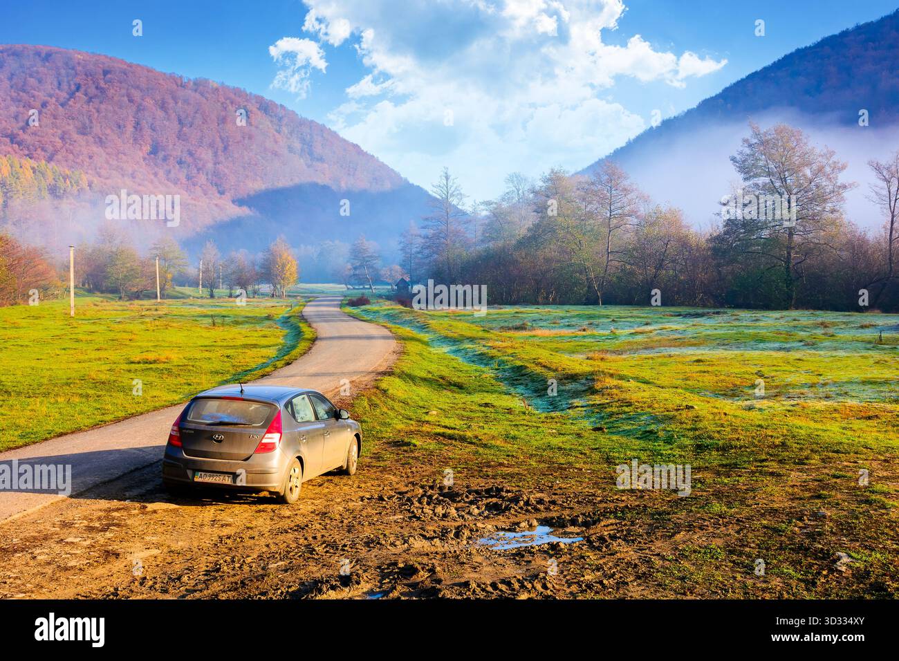 perechyn, ucraina - 10 novembre 2020: auto vicino alla strada asfaltata in autunno. viaggio attraverso il paesaggio di campagna montano dell'ucraina con la nebbia mattutina. cappello hyundai Foto Stock