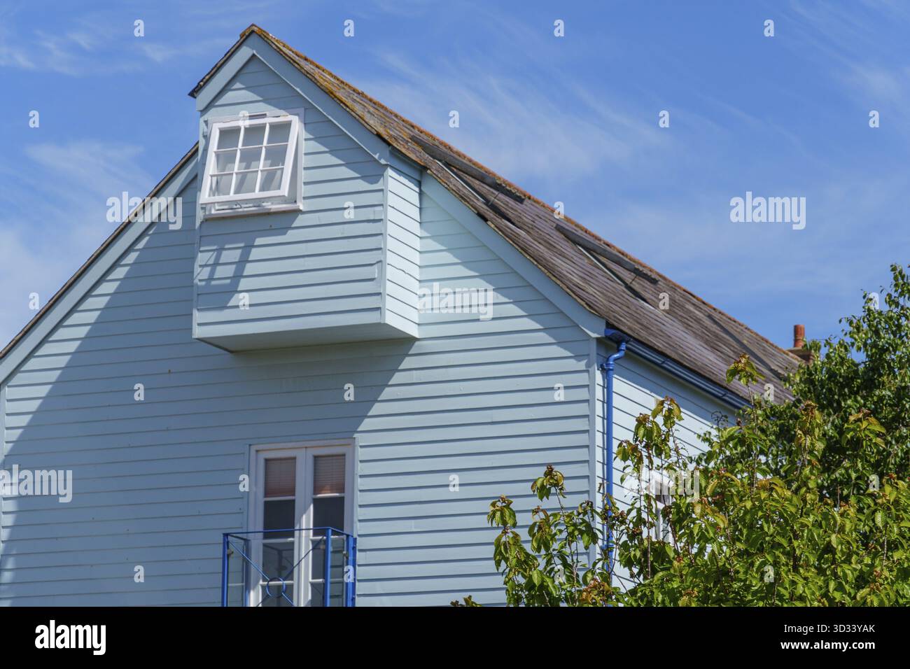 Casa azzurra con tetto inclinato e finestre sul cielo blu, Isola di Portland, Inghilterra, Gran Bretagna Foto Stock