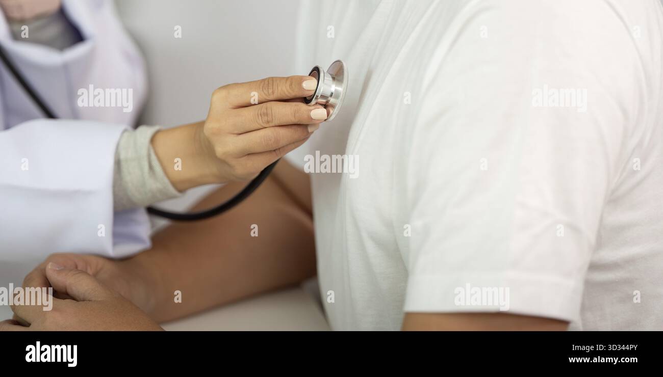 Un operatore sanitario controlla il battito cardiaco di un paziente con uno stetoscopio, sottolineando l'importanza di regolari controlli sanitari Foto Stock