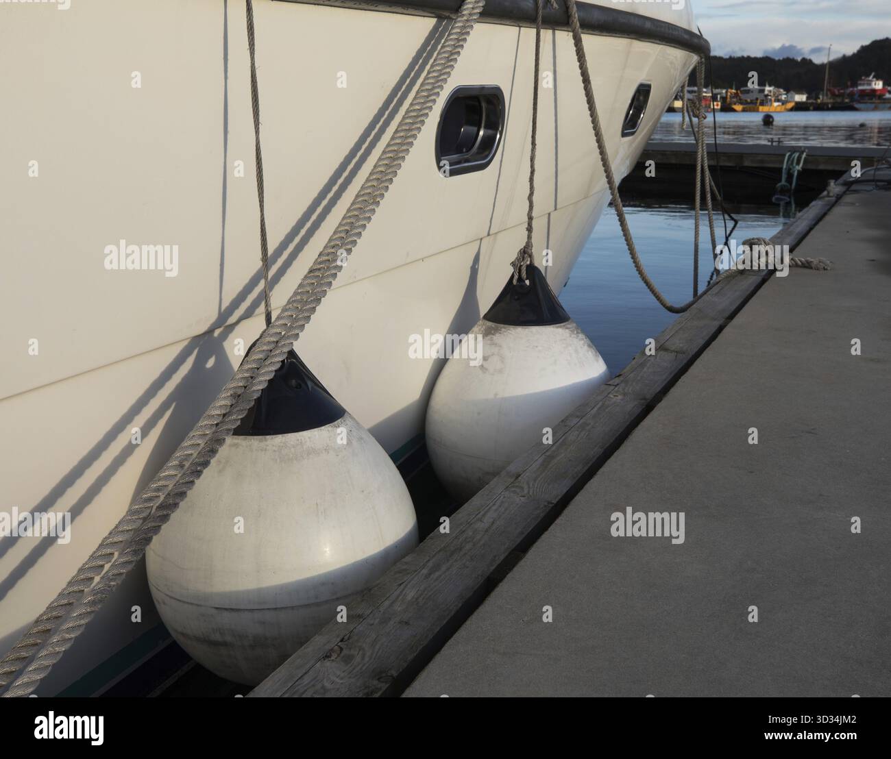 Parafanghi tra l'ormeggio e l'imbarcazione a motore, per proteggere la nave Foto Stock