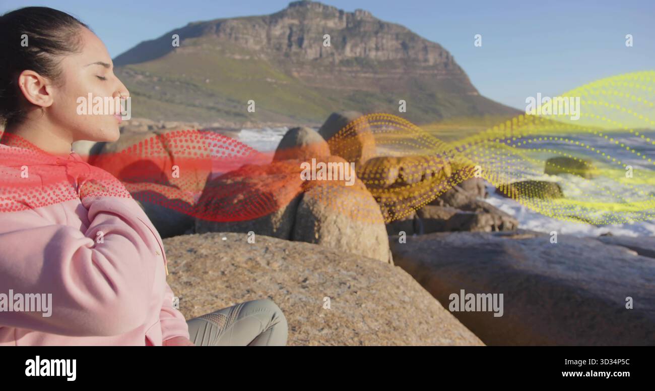 Donna in abbigliamento sportivo che respira sui massi dal mare, dalle onde, dalla montagna, dalla sovrapposizione grafica delle onde, dallo spazio di copia Foto Stock