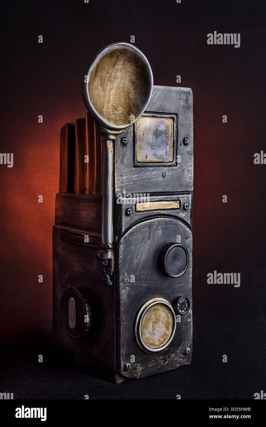 Scultura artistica simile a una macchina fotografica d'epoca, realizzata in modo creativo con metallo testurizzato e un cucchiaio. Una stravagante fusione di nostalgia e immaginazione. Foto Stock