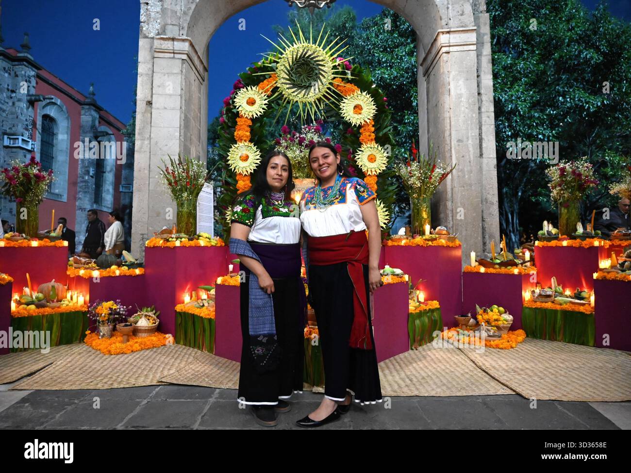 Città del Messico, Messico. 1 novembre 2025. Le donne indigene messicane posano con il tradizionale giorno dei morti ofrenda o altare al Palazzo Nazionale, 1 novembre 2025 a città del Messico, Messico. L'altare colorato è stato creato da donne indigene del National Institute of Indigenous Peoples. Crediti: Saúl López/Ufficio Presidenti messicani/Alamy Live News Foto Stock