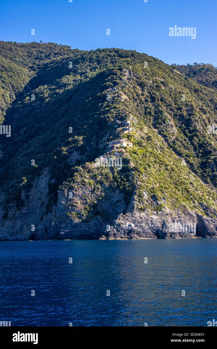 Panorámica de la costa de Liguria y de los coloridos pueblos de cinque Terre vistos desde el mar en un crucero y en día soleado. Liguria, Italia Foto Stock