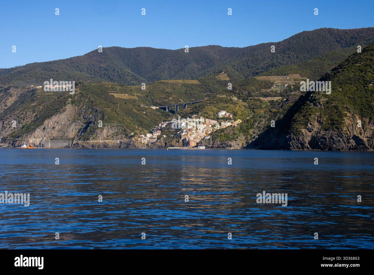 Panorámica de la costa de Liguria y de los coloridos pueblos de cinque Terre vistos desde el mar en un crucero y en día soleado. Liguria, Italia Foto Stock