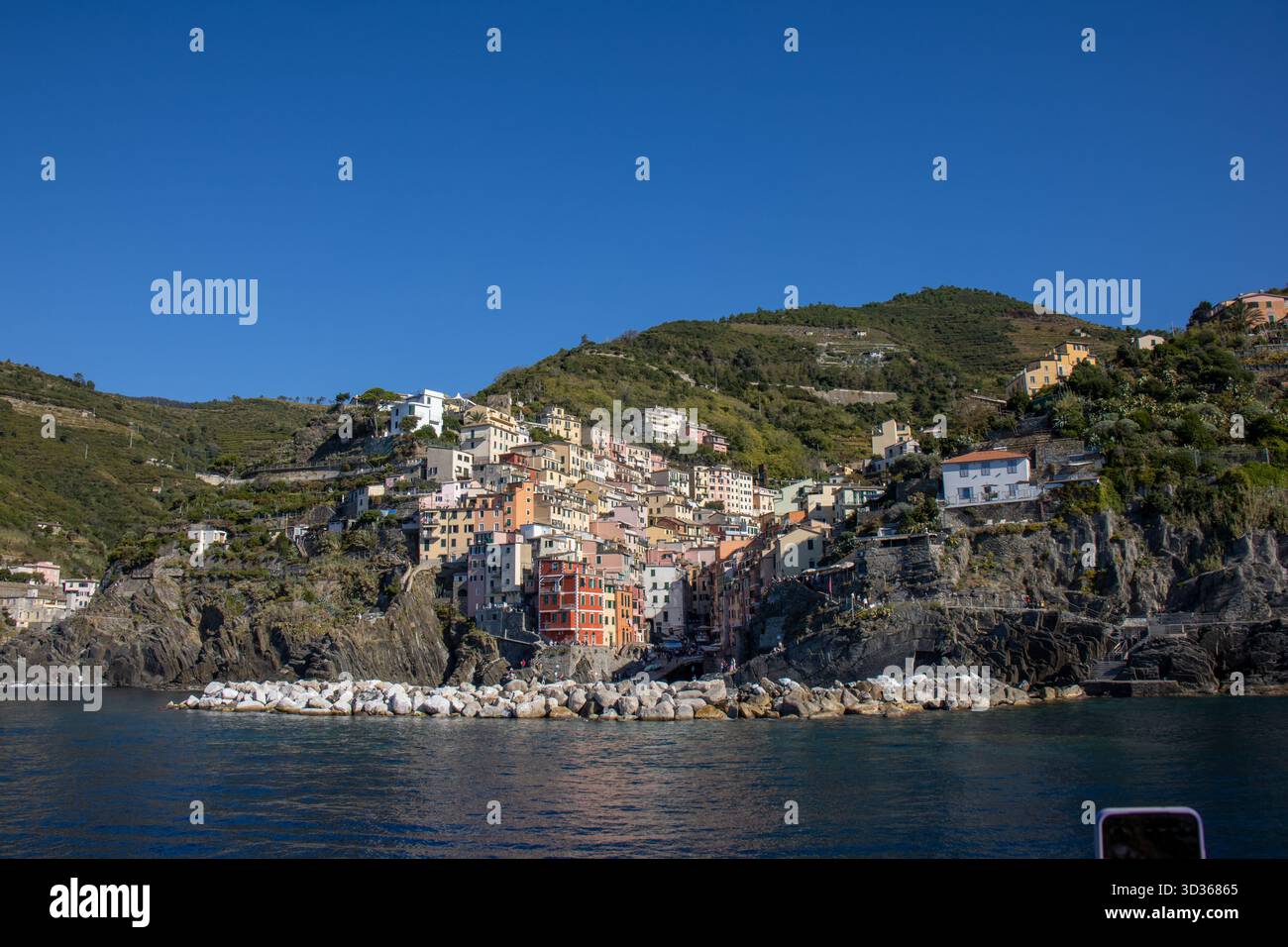 Panorámica de la costa de Liguria y de los coloridos pueblos de cinque Terre vistos desde el mar en un crucero y en día soleado. Liguria, Italia Foto Stock