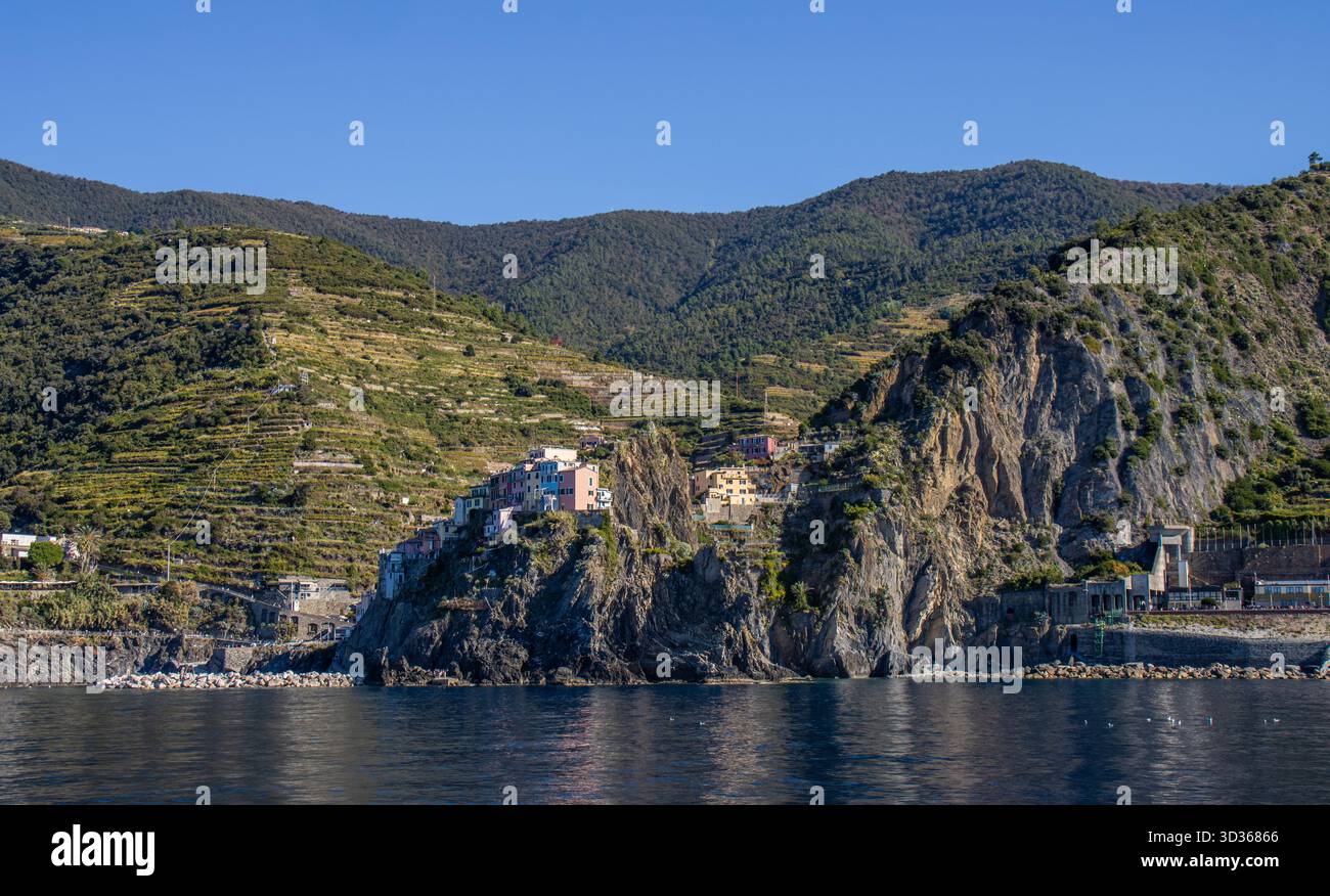 Panorámica de la costa de Liguria y de los coloridos pueblos de cinque Terre vistos desde el mar en un crucero y en día soleado. Liguria, Italia Foto Stock