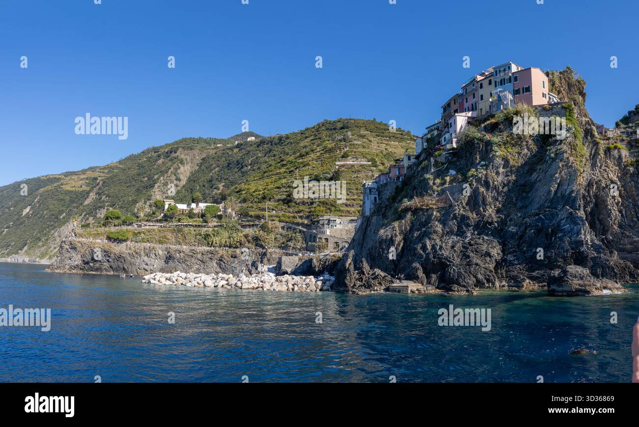 Panorámica de la costa de Liguria y de los coloridos pueblos de cinque Terre vistos desde el mar en un crucero y en día soleado. Liguria, Italia Foto Stock