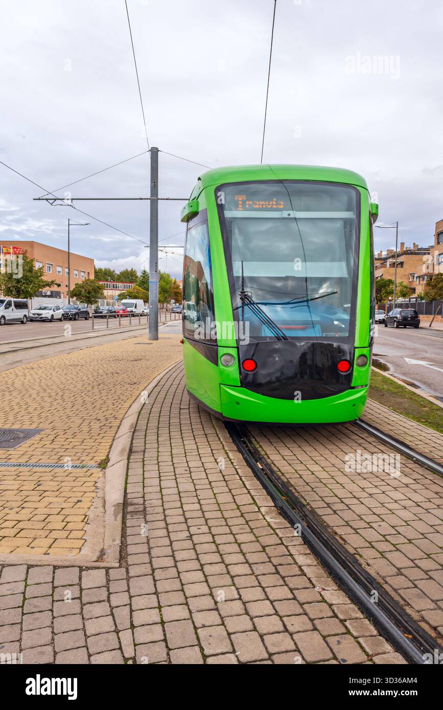 Un tram cittadino che attraversa la città in una giornata nuvolosa Foto Stock