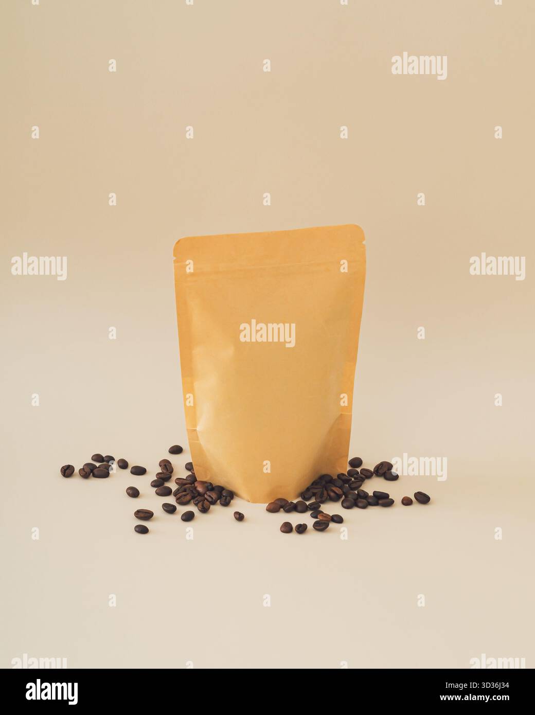 Chicchi di caffè e sacchetto di carta kraft su sfondo beige. Concetto di caffè minimale. Design ecologico. Foto Stock