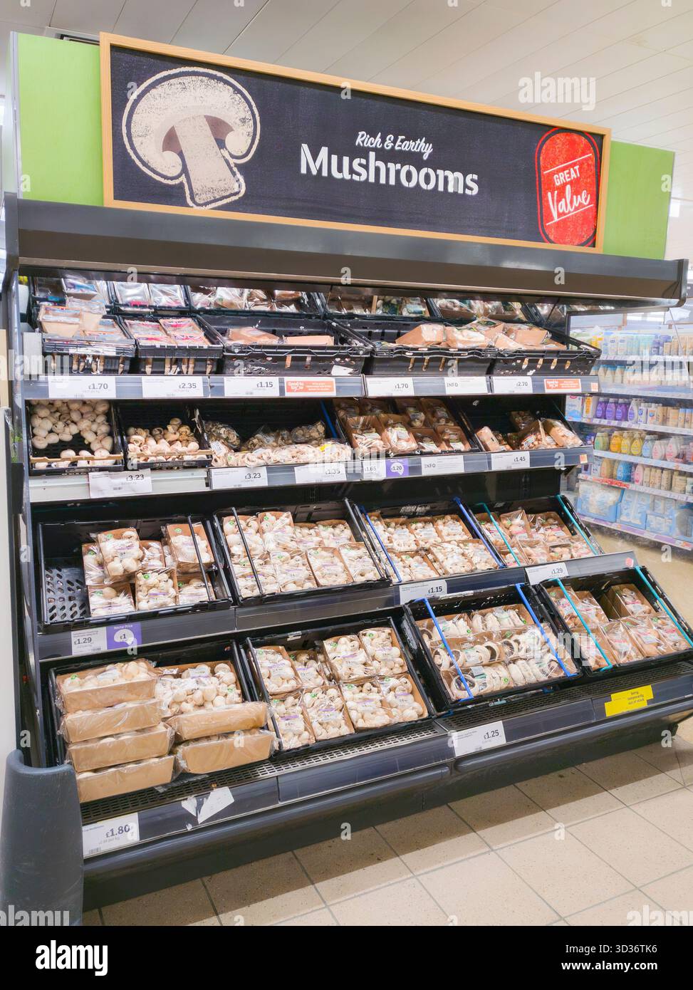 Funghi sciolti e preconfezionati alla fine della navata in vendita al supermercato Sainsbury con un cartello "grande rapporto qualità-prezzo" e "ricco e terroso", Inghilterra Foto Stock