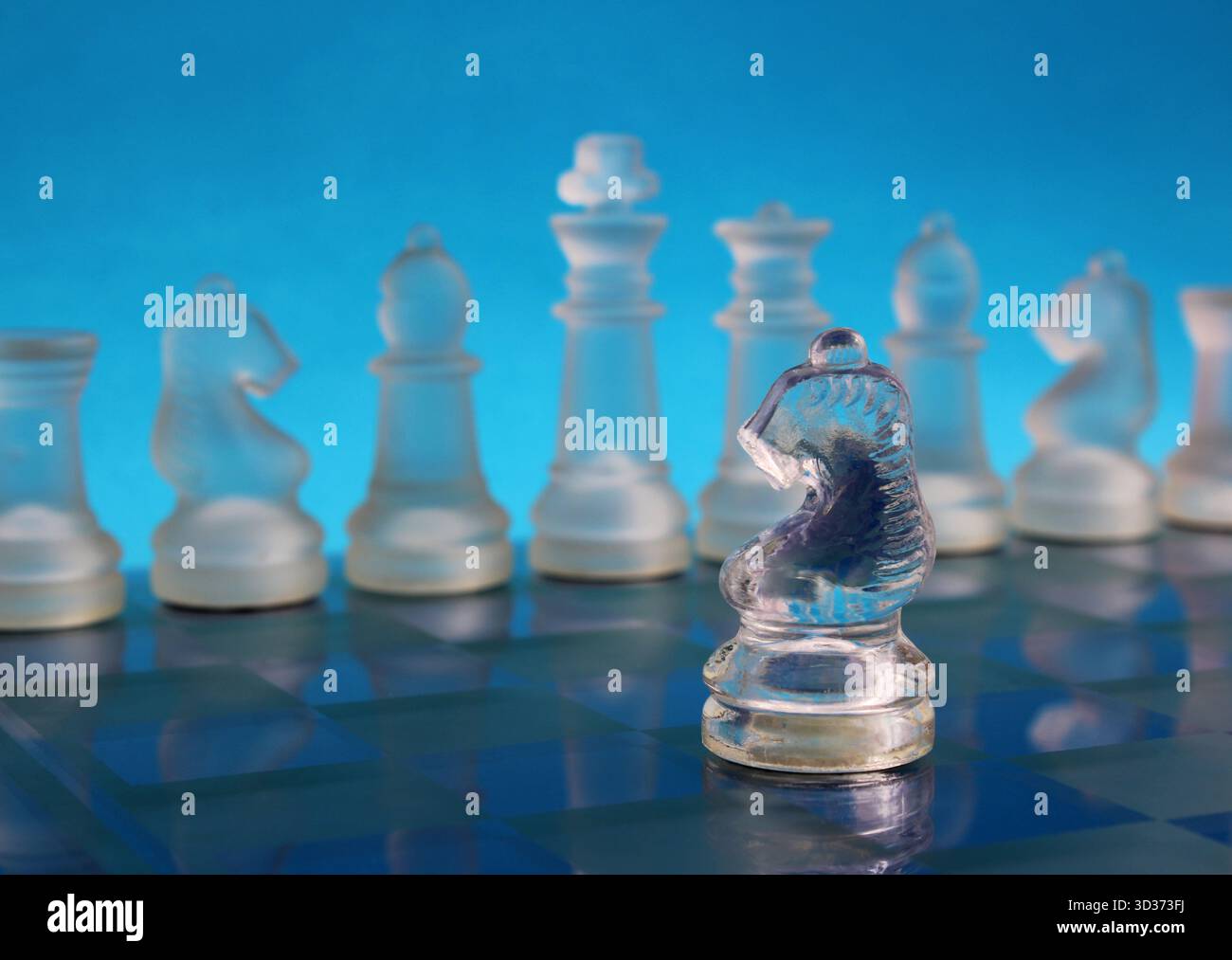 Cavallo opposto che affronta una fila di pezzi di scacchi su una scacchiera, simboleggiando strategia, leadership e pensiero chiaro negli affari o nel processo decisionale Foto Stock