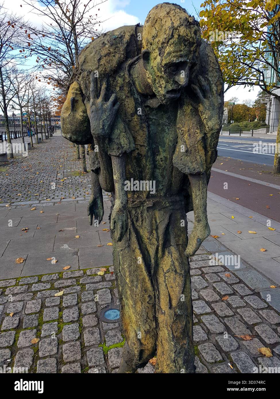 Il Famine Memorial di Rowan Gillespie sul Custom House Quay a Dublin City Docklands, Irlanda, grande carestia irlandese con fiume Liffey in bronzo Foto Stock