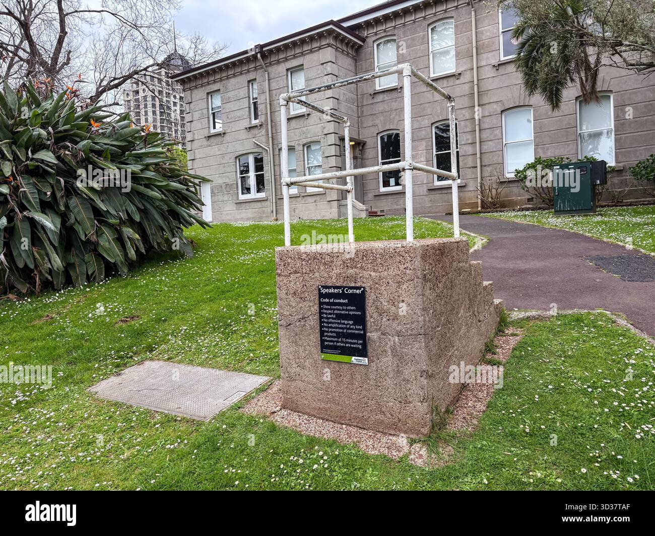 Speakers' Corner, una storica piattaforma di comunicazione pubblica ad Albert Park, Auckland, nuova Zelanda, con un cartello con il codice di condotta e delle ringhiere. Foto Stock