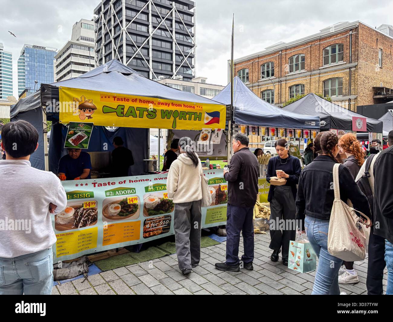 Il mercato del sabato Britomart ad Auckland, nuova Zelanda, presenta uno stand di cibo filippino chiamato "Eats Worth" che serve piatti popolari come Sisig e. Foto Stock