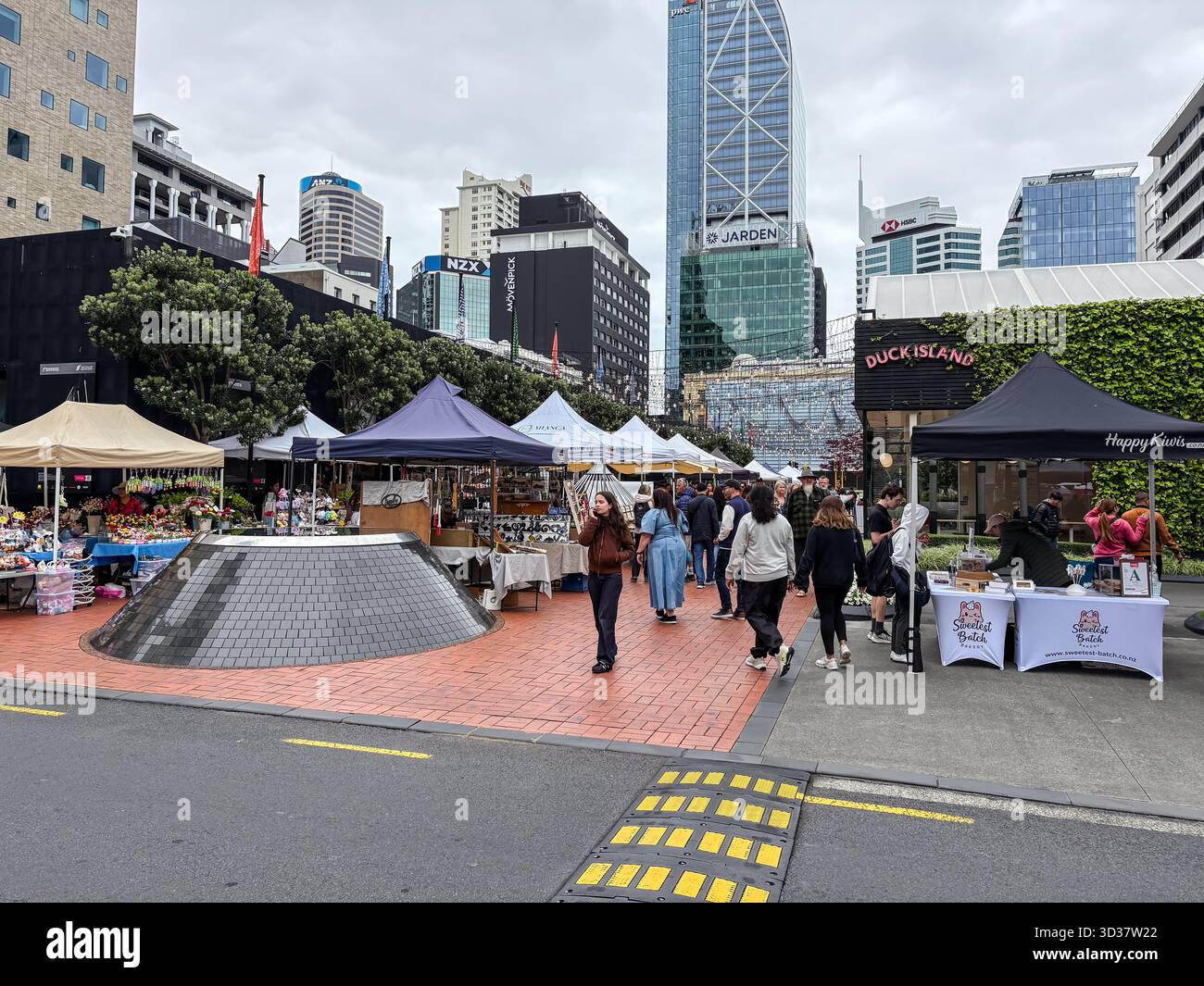 Mercato del sabato Britomart ad Auckland, nuova Zelanda, con varie bancarelle di venditori sotto le tende con gente che cerca merci. Moderni edifici cittadini Foto Stock