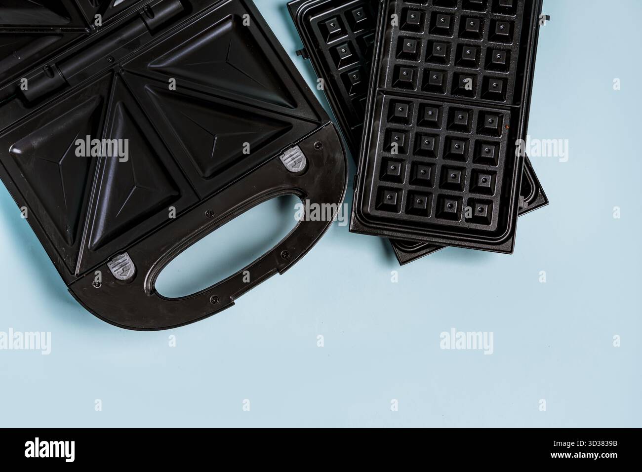 Ferro elettrico per waffle con bocchette per sandwich e waffle su sfondo blu Foto Stock