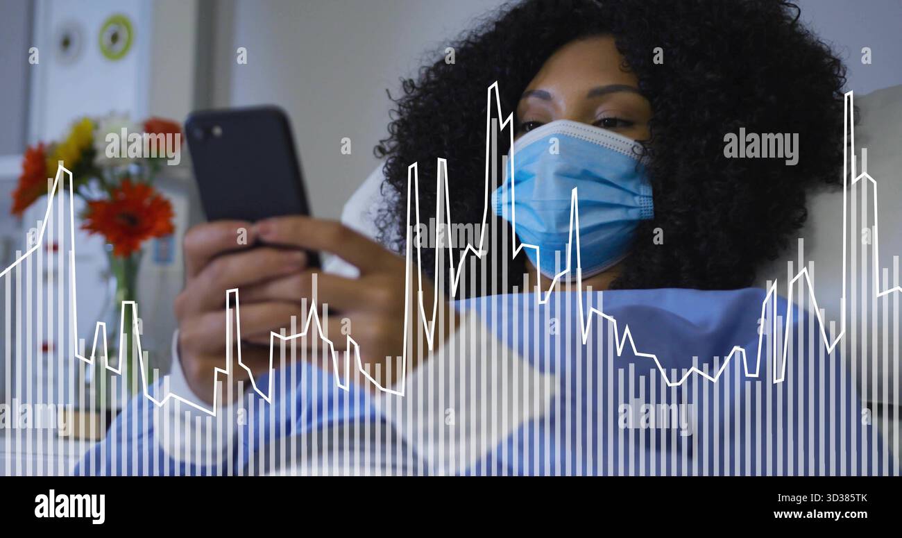 Paziente che indossa maschera e camice sdraiato nel letto che regge lo smartphone, accanto ai fiori del vaso e alle uscite del gas Foto Stock