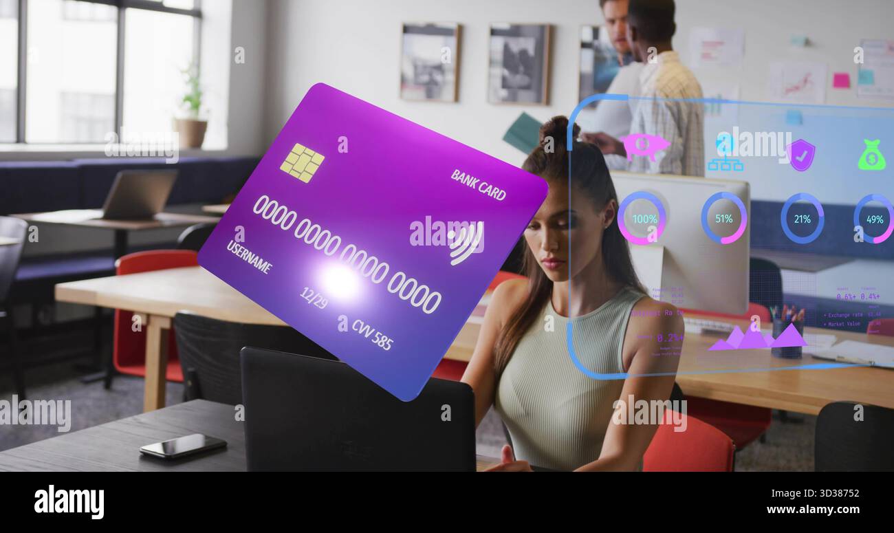 Carta di credito olografica fluttuante che passa sopra il laptop sulla scrivania dell'ufficio open space, con icone finanziarie Foto Stock