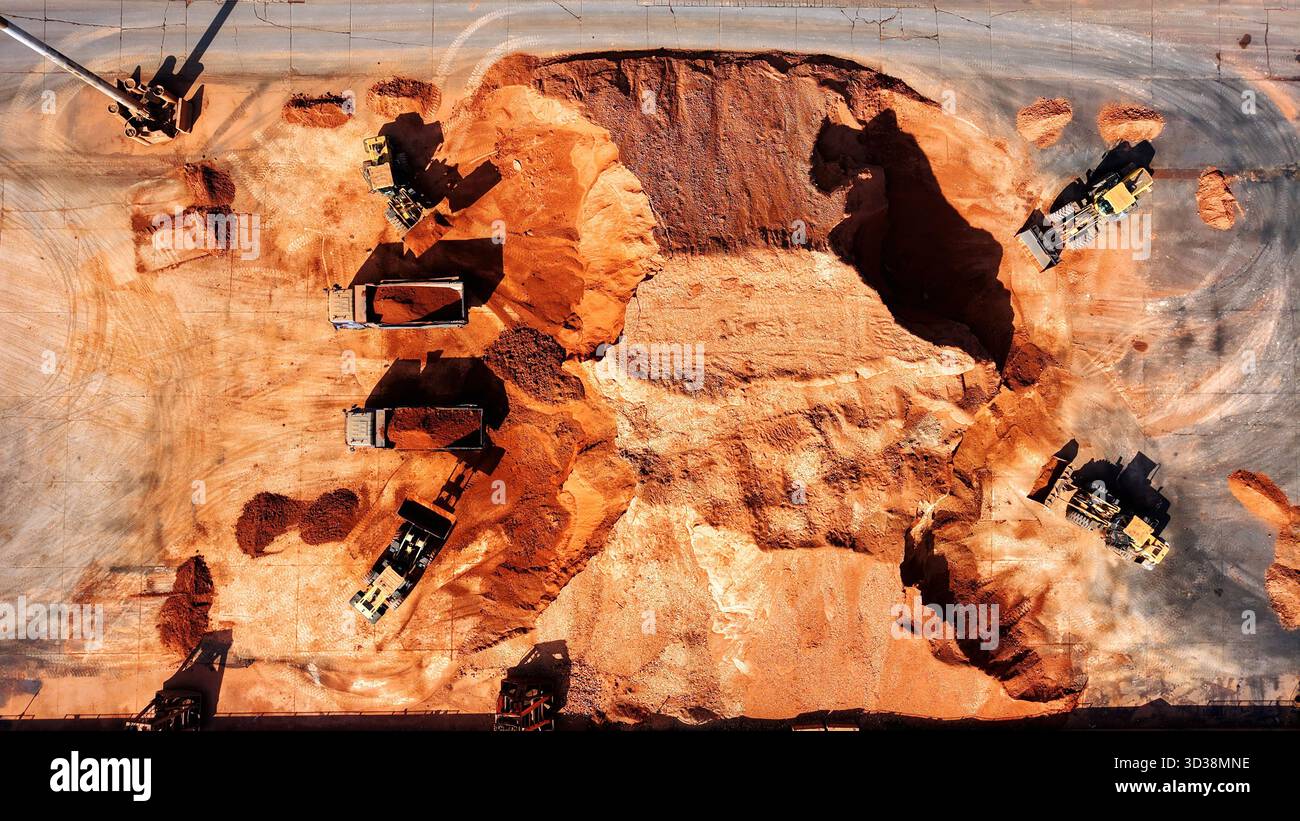 Il 5 novembre 2025, Engineering Machinery sta effettuando la selezione e il caricamento di minerali di ferro presso il terminal del porto di Qingdao a Qingdao, nella provincia di Shandong, in Cina. Foto Stock