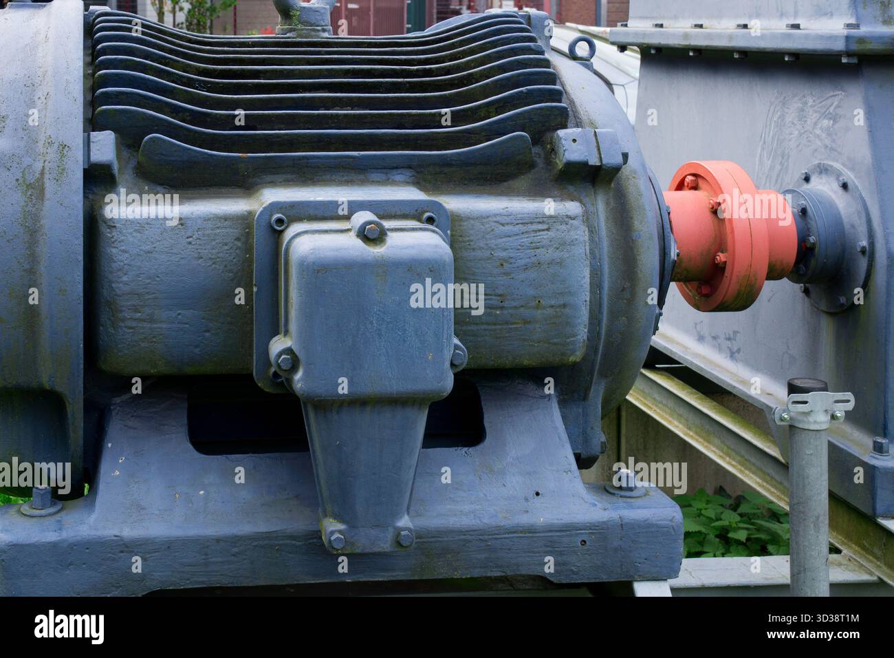 Primo piano dell'alloggiamento di macchinari industriali che mostra alette di raffreddamento e struttura metallica con bulloni. Foto Stock