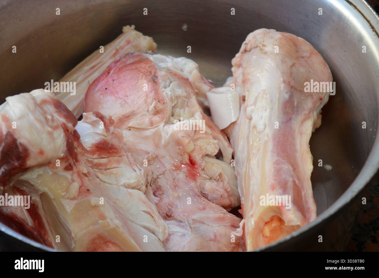 Diversi pezzi di ossa di manzo crude in una pentola, preparati per la preparazione di brodo osseo, zuppa di midollo osseo o brodo, il brodo osseo è un liquido denso di nutrienti prodotto Foto Stock