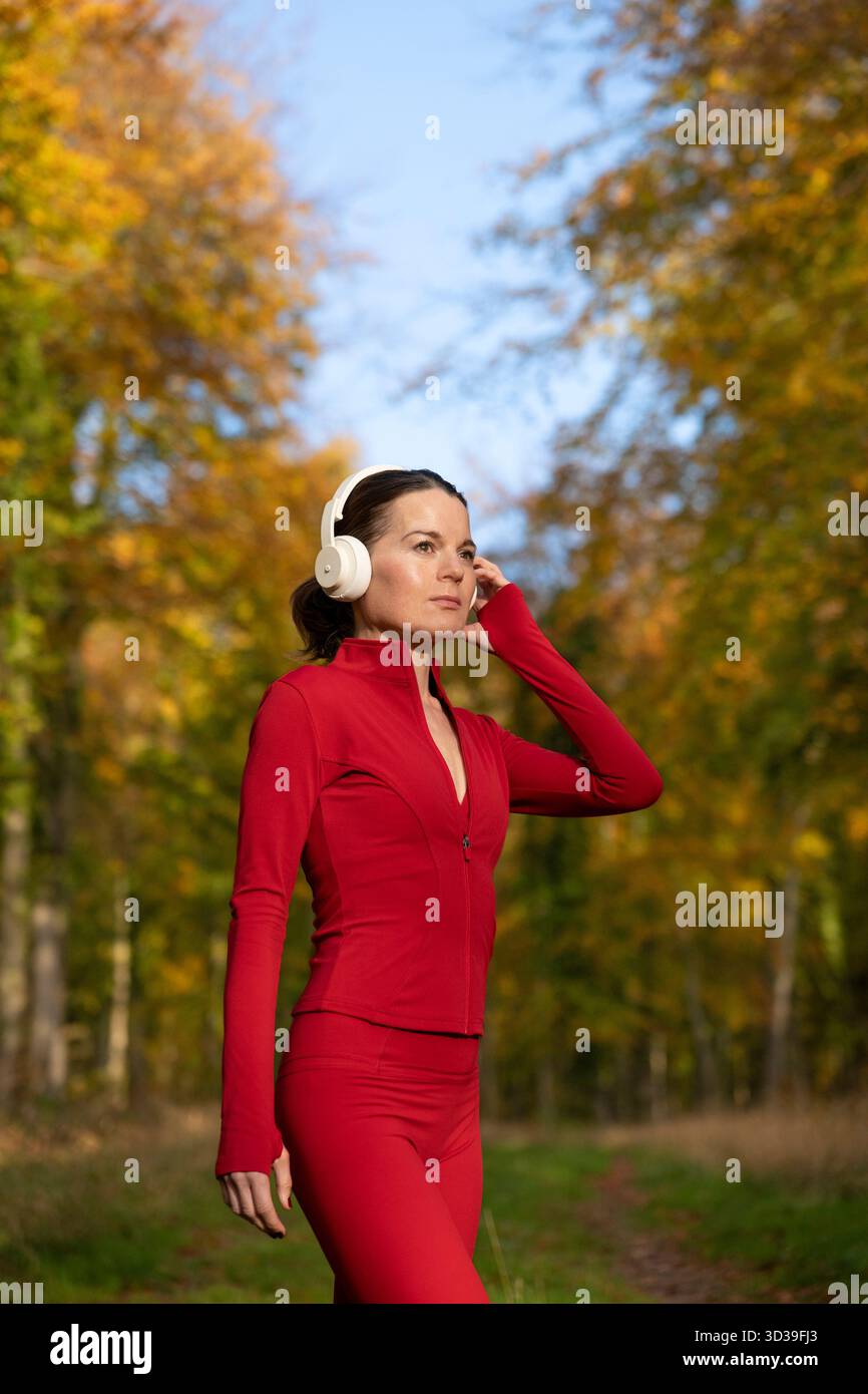 indossate una donna sportiva che indossa le cuffie per allenarsi al parco Foto Stock