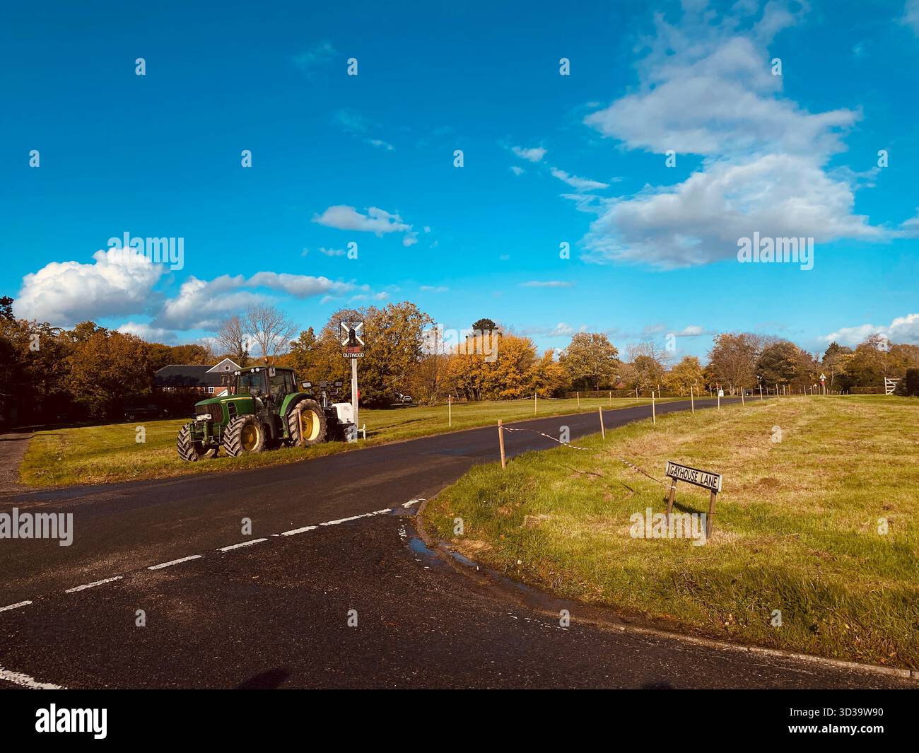 Outwood Village Surrrey, incrocio con un trattore parcheggiato accanto all'insegna del villaggio - Immagine stock catturata con smartphone
