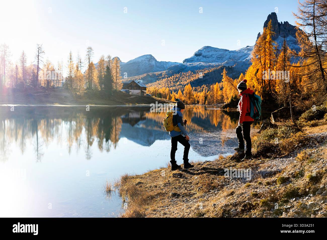 Turisti che si godono al lago di Croda da lago vicino a Cortina d'Ampezzo nelle dolomiti in italia, vacanze escursionistiche in famiglia, fogliame autunnale, larici Foto Stock