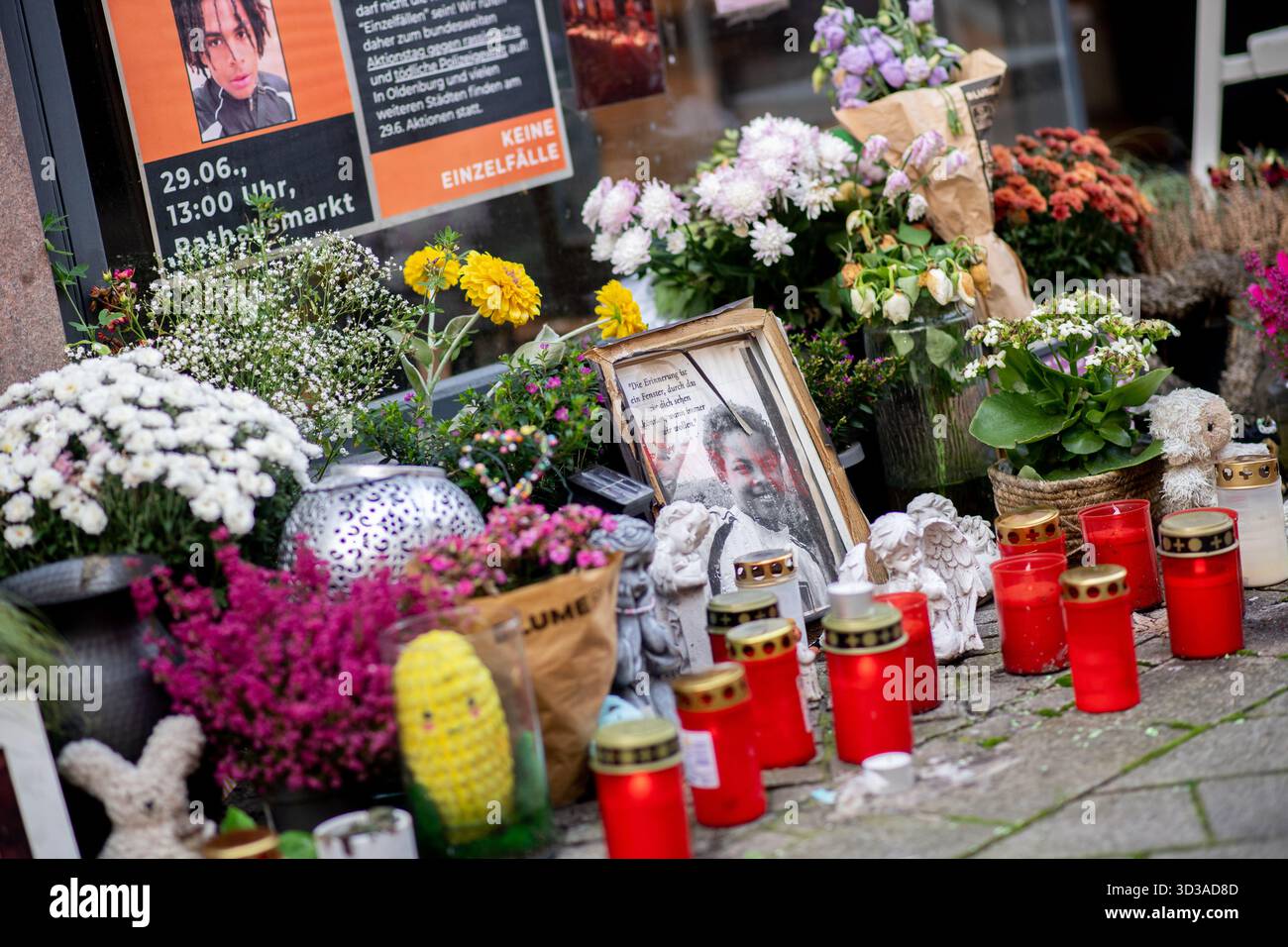 Oldenburg, Germania. 5 novembre 2025. Foto, fiori e candele sulla scena del crimine nel centro della città commemorano Lorenz, ferita a morte da un colpo di pistola della polizia. Dopo la sparatoria fatale del ventunenne, l'ufficio del pubblico ministero ha accusato un agente di polizia per omicidio colposo. Crediti: Hauke-Christian Dittrich/dpa/Alamy Live News Foto Stock