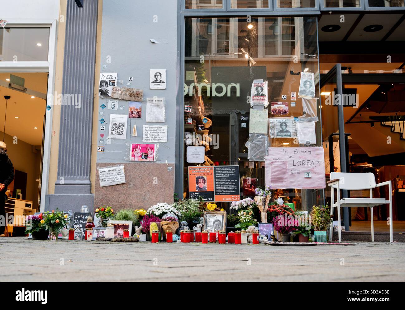 Oldenburg, Germania. 5 novembre 2025. Foto, fiori e candele sulla scena del crimine nel centro della città commemorano Lorenz, ferita a morte da un colpo di pistola della polizia. A seguito della sparatoria mortale di Lorenz ventunenne a Oldenburg, l'ufficio del pubblico ministero ha accusato un agente di polizia per omicidio colposo. Crediti: Hauke-Christian Dittrich/dpa/Alamy Live News Foto Stock