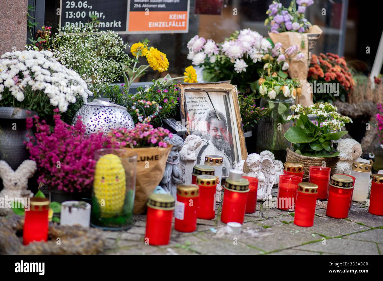 Oldenburg, Germania. 5 novembre 2025. Numerose foto, fiori e candele sulla scena del crimine nel centro della città commemorano Lorenz, ferita a morte da un colpo di pistola della polizia. Dopo la sparatoria mortale di Lorenz ventunenne a Oldenburg, l'ufficio del pubblico ministero ha accusato un agente di polizia per omicidio negligente. Crediti: Hauke-Christian Dittrich/dpa/Alamy Live News Foto Stock