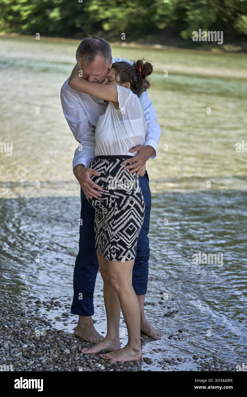 Donna affettuosa con batuffolo appoggiata a un partner affidabile con attaccamento emotivo che le dà sostegno e sostegno sull'Isar di Monaco, Baviera Foto Stock
