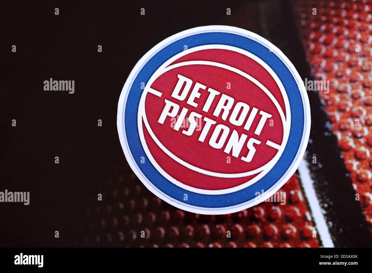 KIEV, UCRAINA - 23 FEBBRAIO 2025 il distintivo della squadra di basket dei Detroit Pistons si trova sullo sfondo della palla di basket Foto Stock