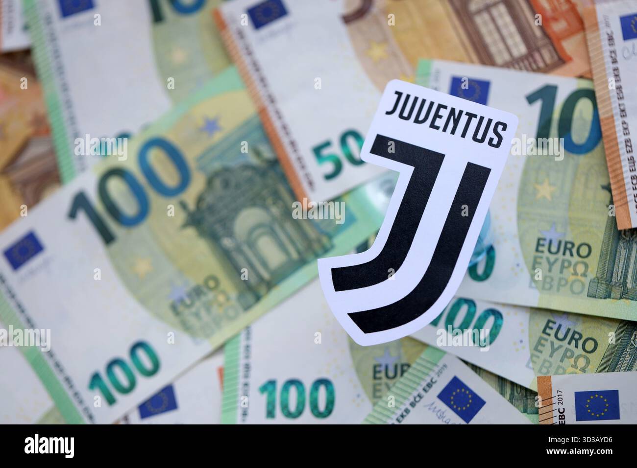 KIEV, UCRAINA - 23 FEBBRAIO 2025 il distintivo della squadra di calcio della Juventus FC si trova su una grossa somma di cento banconote in denaro Foto Stock