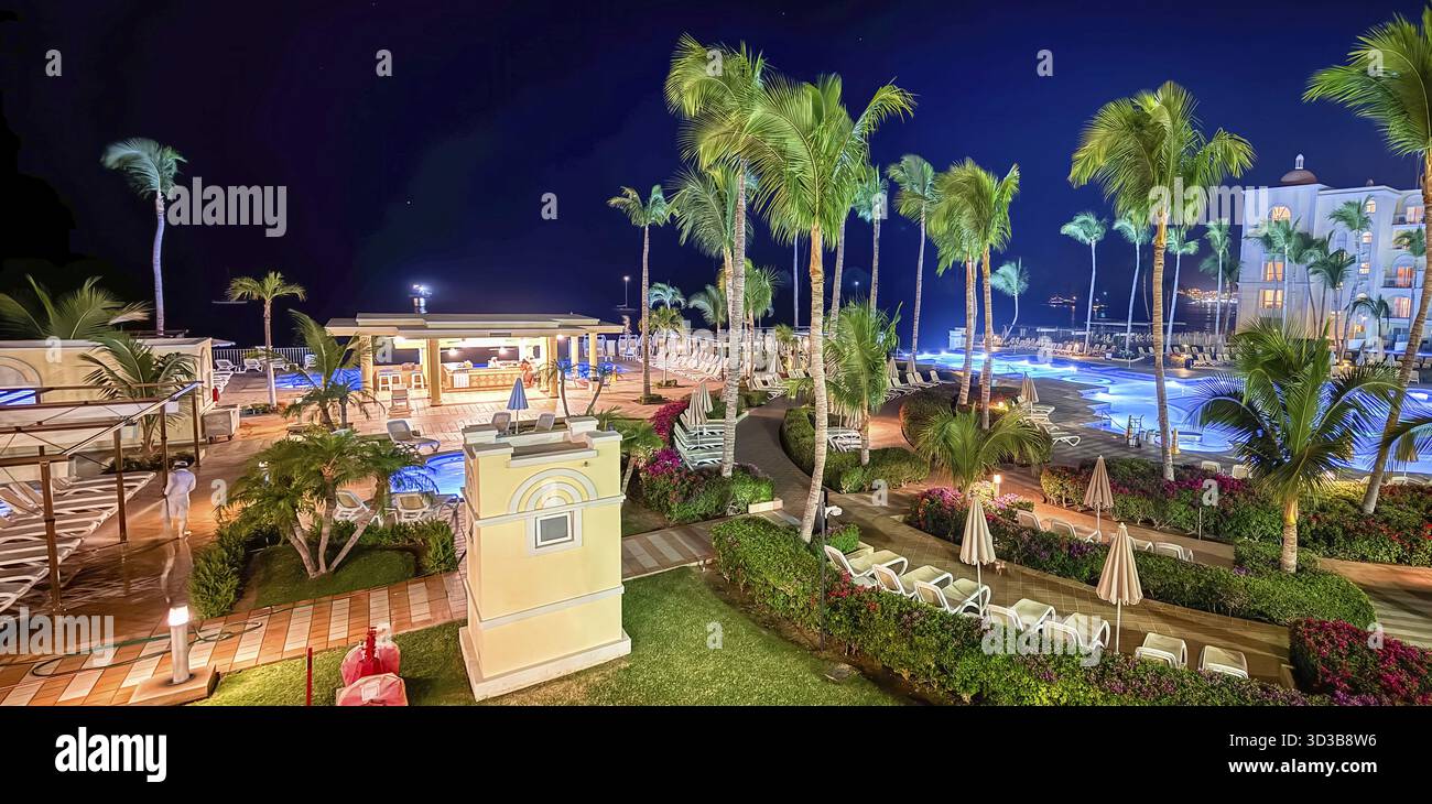 Los Cabos, B.C.S, Messico. 29 dicembre 2024. Un hotel tropicale RIU al chiaro di luna. Le piscine luminose brillano tra palme ondeggianti, creando un ambiente sereno e invitante Foto Stock